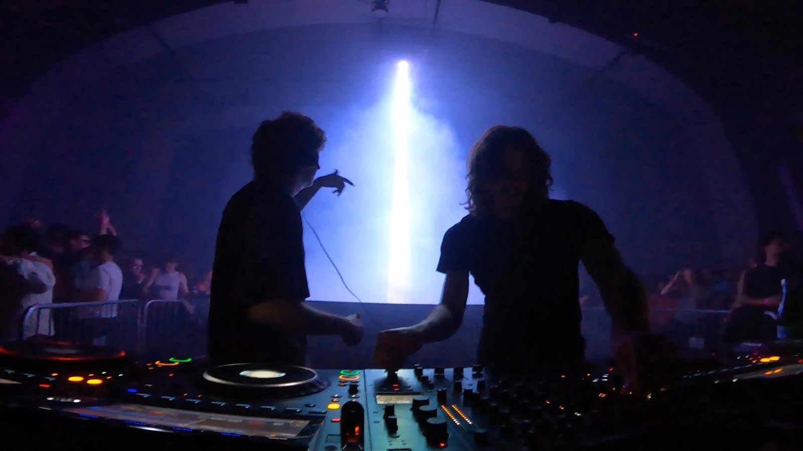 INVT DJing at AiBeacon2, two silhouettes at the decks in front of the laser beacon