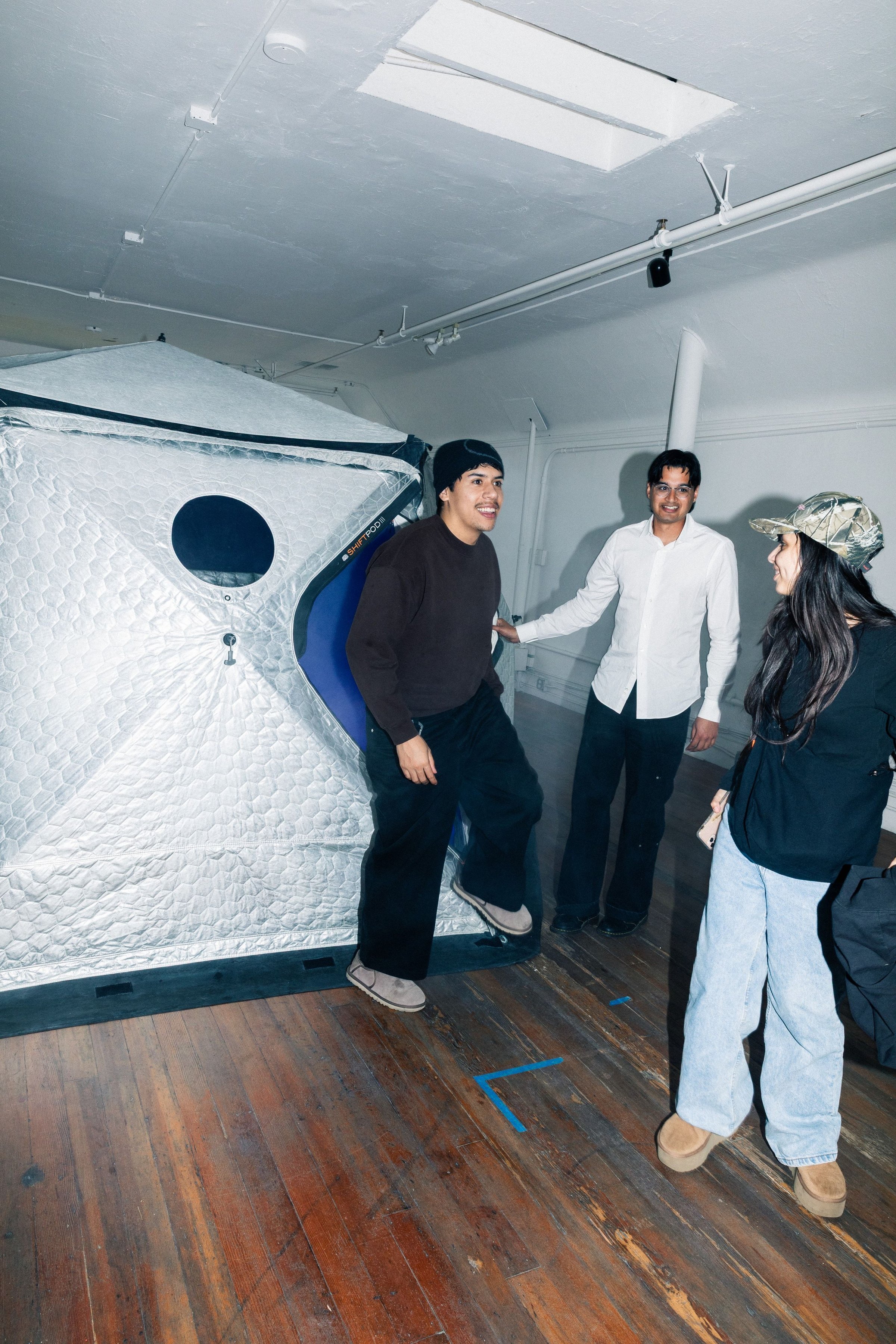 Three guests stepping out of the HoloDome1 tent into the gallery