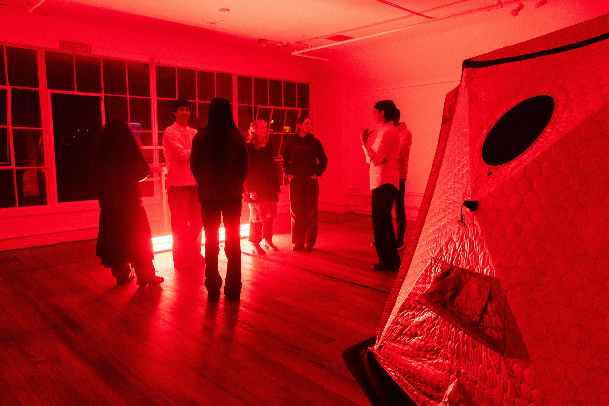 Guests lining up in the red-lit gallery loft outside HoloDome1